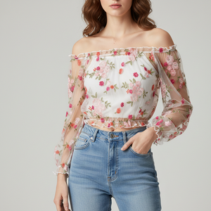 Woman wearing a floral off-shoulder top and blue jeans on a gray background