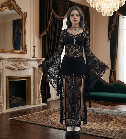 Woman in a black lace outfit standing in an elegant room with a fireplace and green sofa.