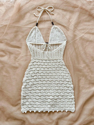 White crochet dress on a beige fabric background
