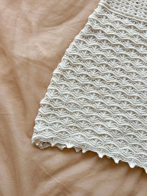 Close-up of textured beige fabric with a wavy pattern on a matching background