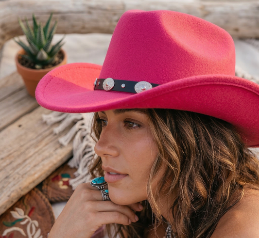 Woman wearing a pink cowboy hat with a wooden background