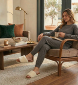 Woman sitting in a chair holding a mug in a cozy living room.
