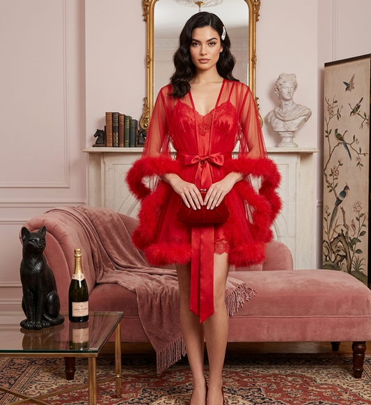 Woman in a red lace robe with fur trim standing in an elegant room.