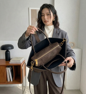 Woman holding a brown leather handbag indoors