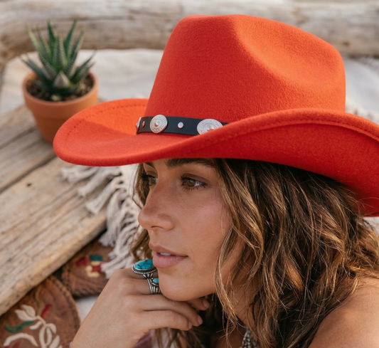 Woman wearing an orange cowboy hat with a wooden background