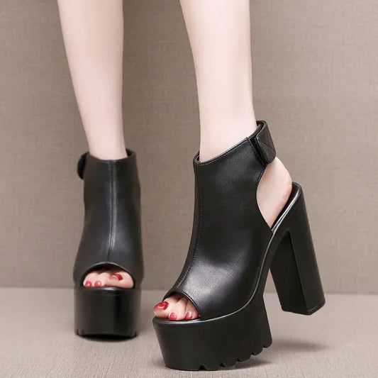 Black high-heeled open-toe shoes on a neutral background