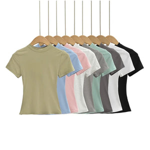 Row of plain t-shirts in various colors on hangers against a white background