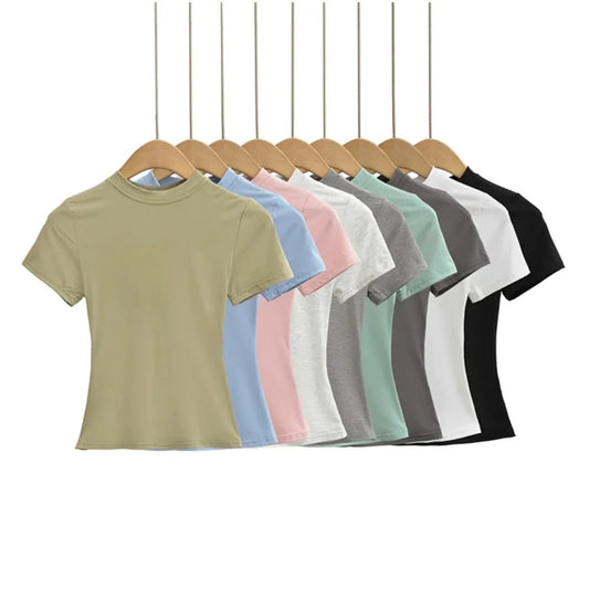 Row of plain t-shirts in various colors on hangers against a white background