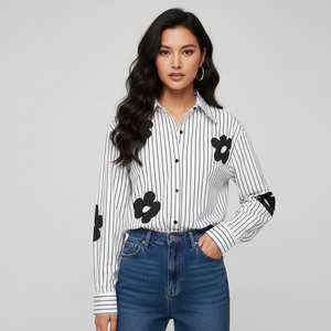 Woman wearing a black and white striped shirt with floral designs on a gray background